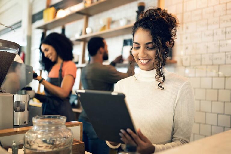 A woman in a restaurant reviewing her workers' compensation strategy and insurance. CRMBC Champions Upcoming Workers’ Compensation Classification Changes