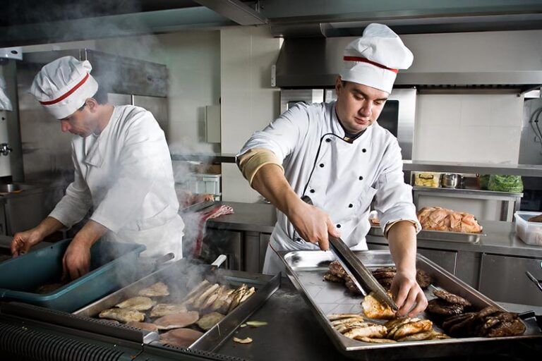 Restaurant workers preparing food in a restaurant, Five Key Strategies to Minimize Restaurant Workplace Injuries