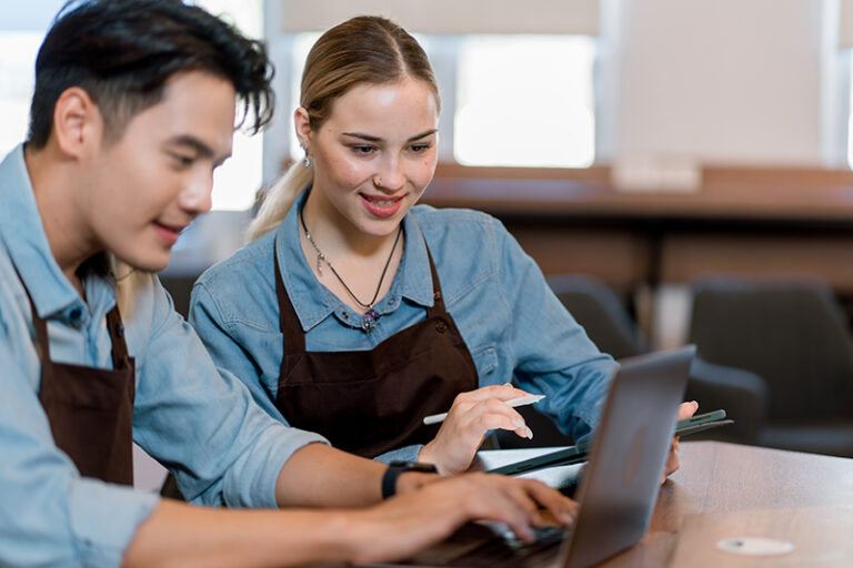 Partnership of cafe barista, entrepreneur and small business owners planning budget. brainstorming coffee shop innovation strategy on laptop, taking notes. Startup entrepreneurs small business meeting